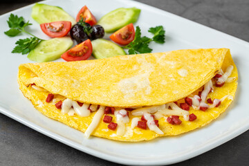 Omelet with feta cheese and Turkish sausage on a white porcelain plate