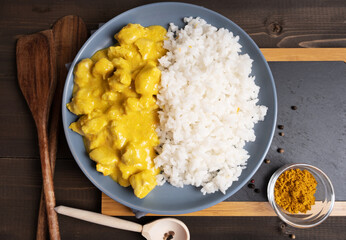 Boiled rice with chicken in curry sauce with spices. Top view.