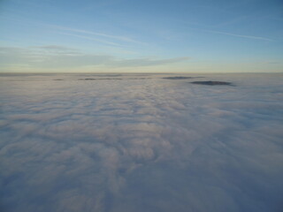 flight above clouds through the cloudy sky