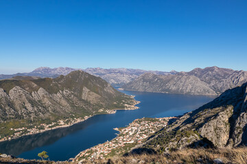 Panoramic view of the bay of Kotor during sunrise in summer, Adriatic Mediterranean Sea, Montenegro, Balkan Peninsula, Europe. Fjord winding along the coastal towns. Lovcen and Orjen mountain range