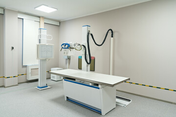 Modern radiology room with fluorography scanning equipment and empty bed for X-ray diagnostic and healthcare exam of patients in hospital - Powered by Adobe