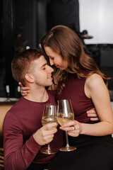 Young couple in love celebrating christmas together with a glass in their hands