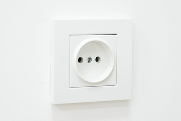 Close up of white electric outlet on white background. Concept of electricity, usage of electrical devices
