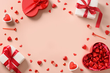 Valentine's day greeting card with red gifts, hearts chocolate sweets and candles on pink background. View from above. Copy space.