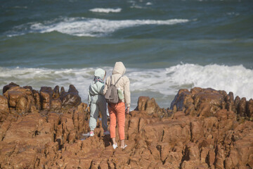 a girl with a child on the shore of the Atlantic Ocean. South Africa