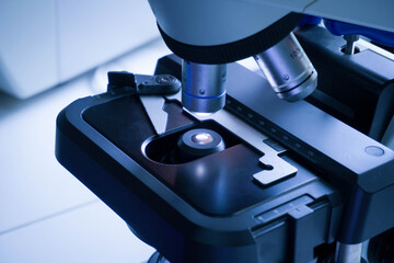 Close-up shot of microscope with metal lens at laboratory. research chemistry equipment scope biotechnology