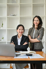 Obraz premium Portrait, Two confident, successful Asian businesswomen in business suits are at the office desk