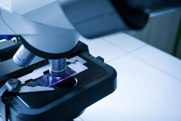 Close-up shot of microscope with metal lens at laboratory. research chemistry equipment scope biotechnology
