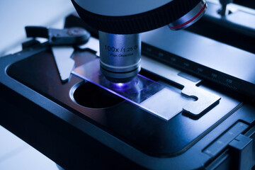 Close-up shot of microscope with metal lens at laboratory. research chemistry equipment scope biotechnology