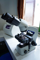 Close-up shot of microscope with metal lens at laboratory. research chemistry equipment scope biotechnology