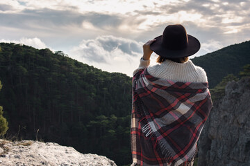 Hiker woman with backpack enjoying mountain view alone outdoors.
Travel and outdoor activities, healthy lifestyle. Beautiful view of the mountains.