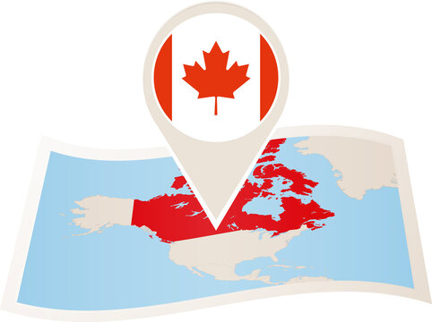 Folded paper map of Canada with flag pin of Canada.
