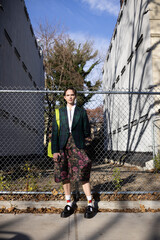 fashion portrait of non-binary person in city with dramatic sunlight