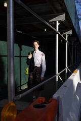 Fototapeta na wymiar fashion portrait of non-binary person in city with dramatic sunlight