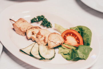 kebab on a wooden skewer and other dishes for a family dinner in the restaurant