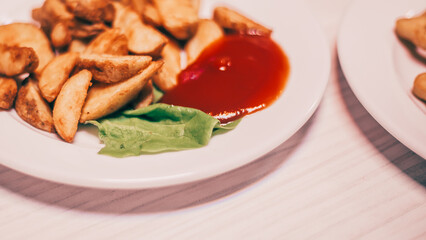 baked potato wedges and tomato sauce on the table