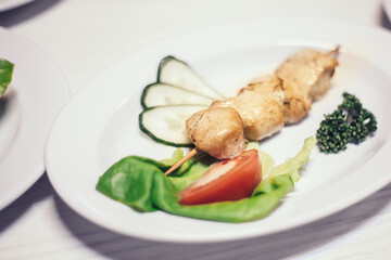 kebab on a wooden skewer with fresh vegetables