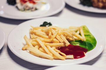 plate with fried potatoes and ketchup on the table