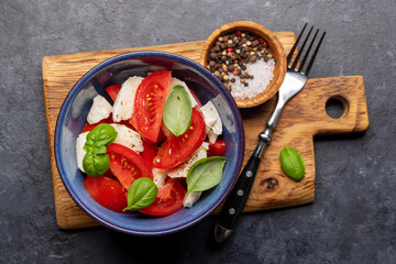 Caprese salad with ripe tomatoes, mozzarella cheese and garden basil