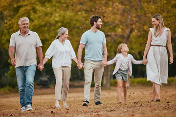 Family walk, holding hands and park with smile, love and bonding with grandparents, kids or happiness. Happy family, walking or relax outdoor on nature adventure by trees, woods or forest