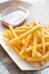 cardboard box of French fries in a takeaway dish of a snack
