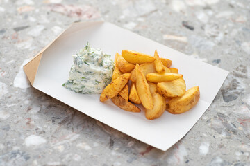 fried potato wedges in kraft paper basket. takeaway food concept