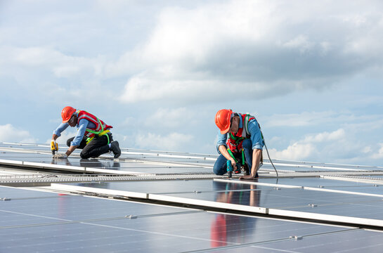 Engineer working setup Solar panel at the roof top. Engineer or worker work on solar panels or solar cells on the roof of business building