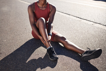 Black woman, fitness and ankle pain, injury and outdoor accident, emergency and first aid risk in city street. Joint pain, bone health and foot trauma of athlete, sports wound and exercise problem