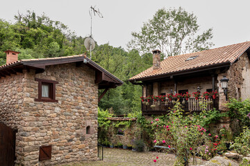Fototapeta na wymiar Stone houses and narrow streets in a mountain village in the north of Spain. Barcena Mayor.