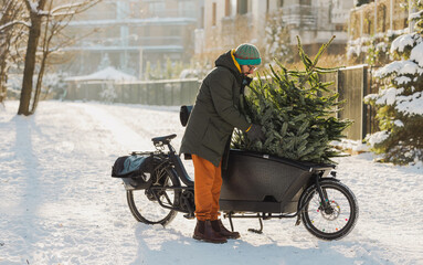 Man transporting Christmas tree on cargo bike 
