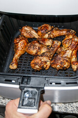 crispy roasted chicken thighs cooked in the basket of the fat-free, low-cholesterol air fryer. Healthy cooking concept