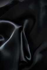 Silk background. Elegant black satin silk with waves, abstract background