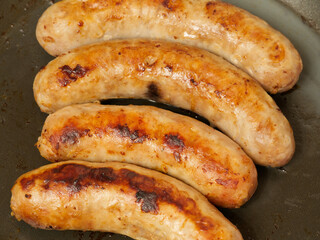 Sausages fried in a frying pan. Closeup