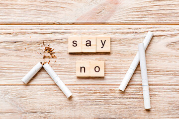 Cigarette And Wooden Blocks, Broken cigarette on table background, No Tobacco Day with hourglass,...