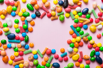 Mixed collection of colorful candy, on colored background. Flat lay, top view. frame of colorful chocolate coated candy
