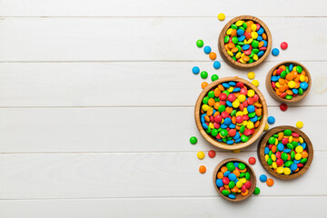 different colored round candy in bowl and jars. Top view of large variety sweets and candies with copy space