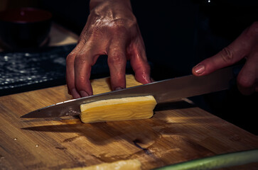 Japanese chef making California Maki Sushi with Masago - Roll made of Crab Meat, Avocado, Cucumber inside. Masago (smelt roe) outside with tuna, salmon, shrimp,traditional Japanese food ,Dark Tone