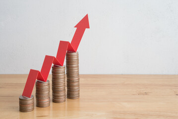 Stack of coins bar chart and red graph growing up with white wall background copy space. Business financial, successful investment, money saving increase, retirement planning, business growing concept