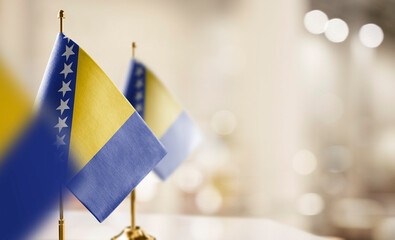 Small flags of the Bosnia and Herzegovina on an abstract blurry background
