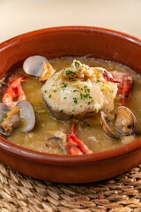 Hake piece with tender garlic, prawns and clams