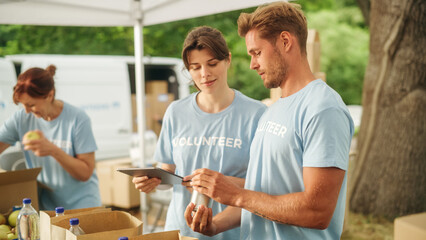 Team of Young Volunteers Helping in a Local Community Food Bank, Preparing Free Meal Rations to Low-Income People in a Park on a Sunny Day. Charity Workers Work in Humanitarian Aid Donation Center.