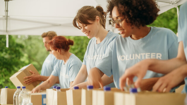 Portrait of a Happy Female Volunteer Preparing Free Food Delivery for Low Income People. Charity Workers and Members of the Community Work Together in Local Humanitarian Aid Donation Center.