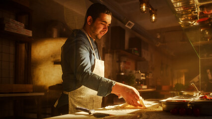 In Restaurant: Portrait of Handsome Professional Chef Preparing Pizza, Kneading Dough, Traditional Recipe. Authentic Pizzeria, Cooking Delicious Organic Food. Cinematic Cozy Interior