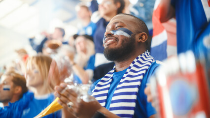 Sport Stadium Big Event: Handsome Black Man Cheering. Crowd of Fans with Painted Faces Cheer, Shout...