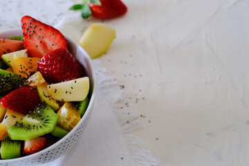 Bowl of healthy fresh fruit salad on a white napkin. Low calories, healthy snack