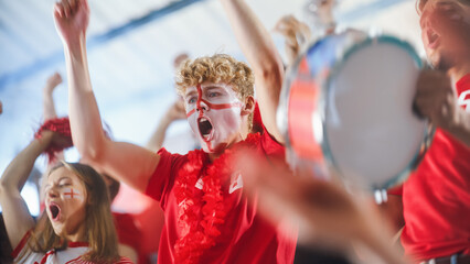 Sport Stadium Big Event: Handsome Expressive Man with Painted face Jumping Up and Cheering Goal...