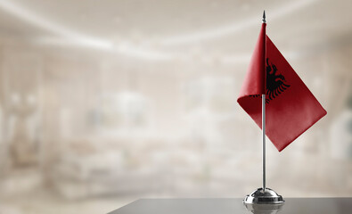 A small Albania flag on an abstract blurry background