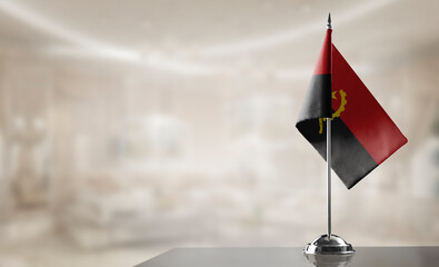 A small Angola flag on an abstract blurry background