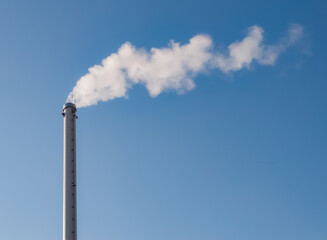 Factory chimney with smoke. Industrial pipe. Blue sky at sunny day. Air pollution/