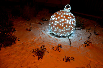 Christmas themed ornaments outside in a snowy park, or on. pedestrian promenade. metal skeleton in...